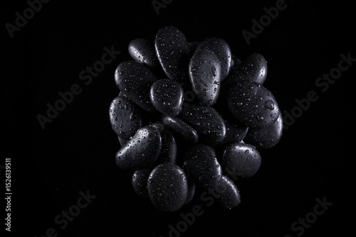 Black natural stones with dramatic lighting showing texture and reflections