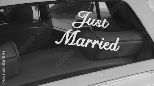 Just Married Sign On Rear Window Of Vintage Car Black And White Close View. Classic Wedding Message On Back Glass Of Retro Vehicle Monochrome Photograph