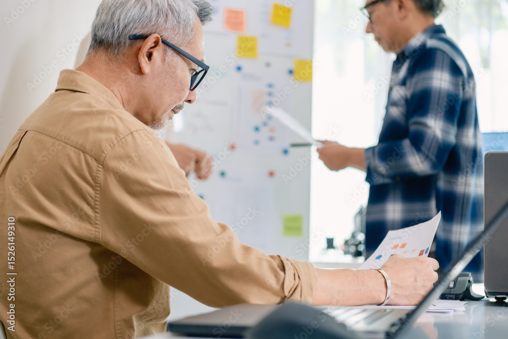 Obraz premium senior programmer bootcamlp,Asian young instructor guides senior learners through a programming on whiteboard, highlighting algorithm thinking and simple code exercises