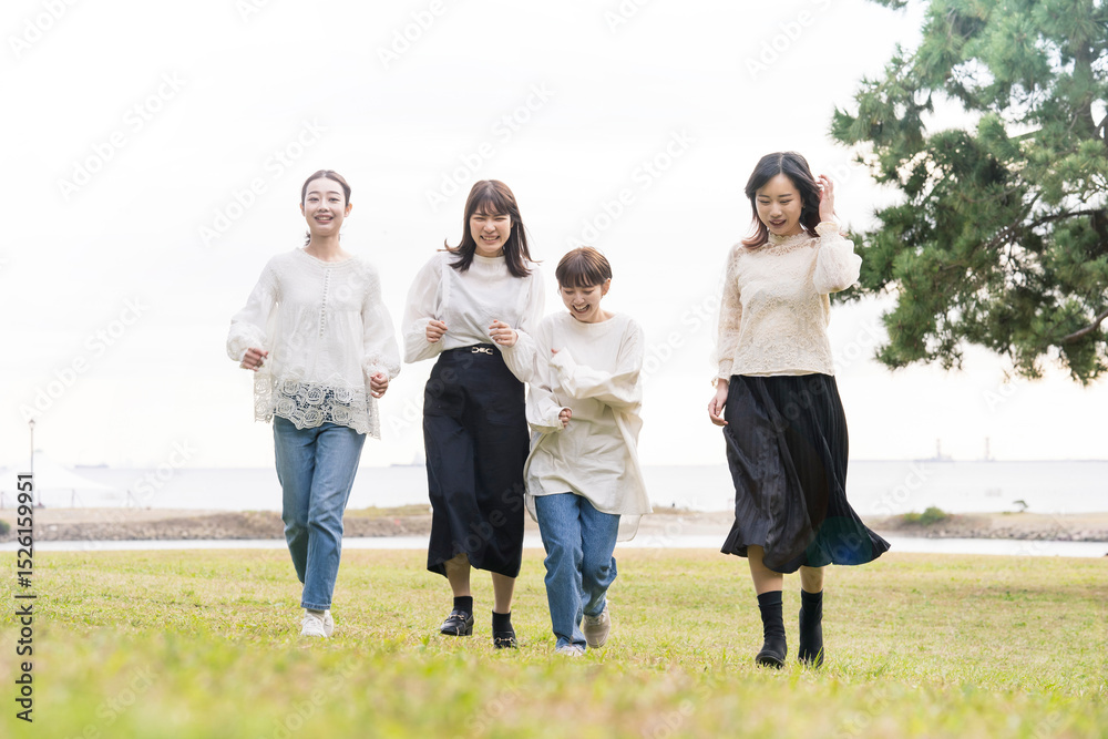 笑顔で話しながらゆっくり走る女性4人 笑顔で話しながらゆっくり走る女性4人