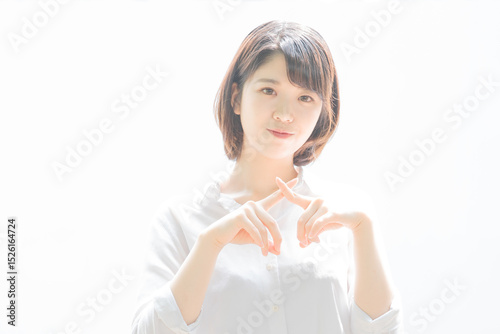 「バツ」のサインを作る若い女性