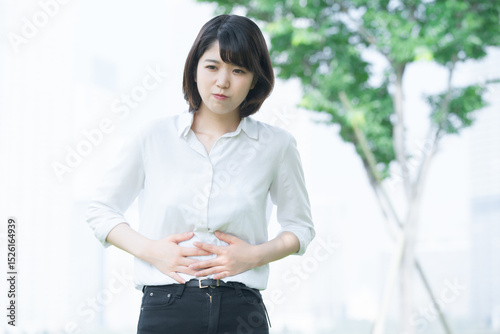 お腹を押さえる若い女性
