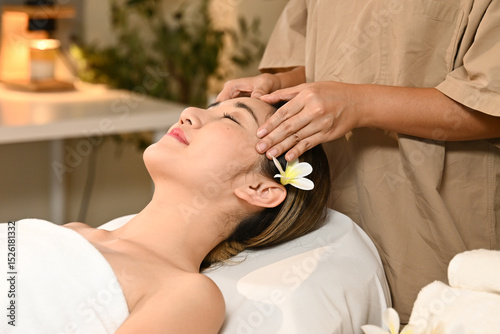 Beautiful Asian woman getting a face massage at the spa