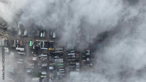 Aerial view of a cityscape covered in dense, fluffy clouds, creating a serene white blanket.