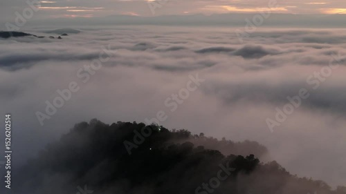 Aerial view of misty mountains at sunrise with a serene and peaceful atmosphere.