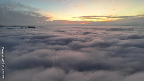 A breathtaking view above the clouds at sunset, showcasing a serene sky and distant horizon.