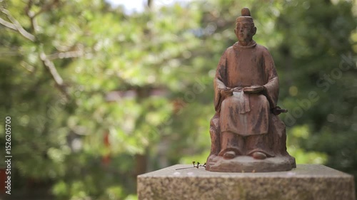 A detailed look at a bronze statue representing a historical figure, situated in Fushimi Inari, Japan, Kyoto