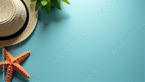 Summer beach hat, starfish, and green plant on blue background   photo