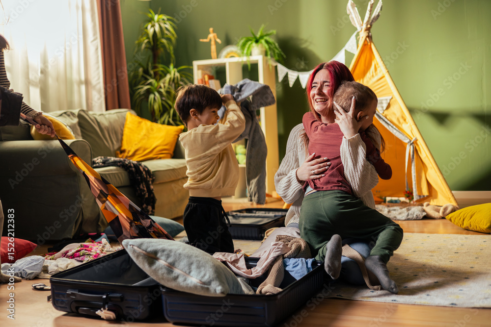 Fototapeta premium Happy family packing suitcases for holiday trip