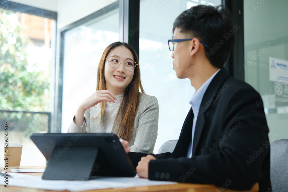 Two business people discuss financial strategy and collaborate with colleagues. Two business people discuss financial strategy and collaborate with colleagues.
