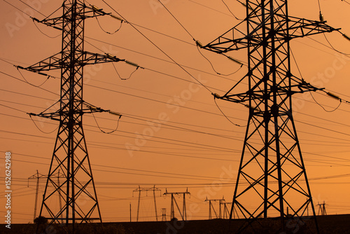 High-voltage power line in the field. Electricity pylons in the evening. Electric tower. Power transmission lines. energy security and clean energy.  