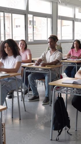 Teacher explaining lesson to diverse high school students