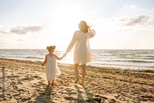 Fényképezés Happy mother and daughter strolling together on a sunny beach