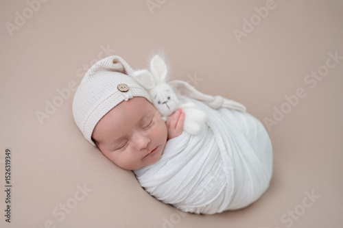 Peaceful newborn baby wrapped in white blanket