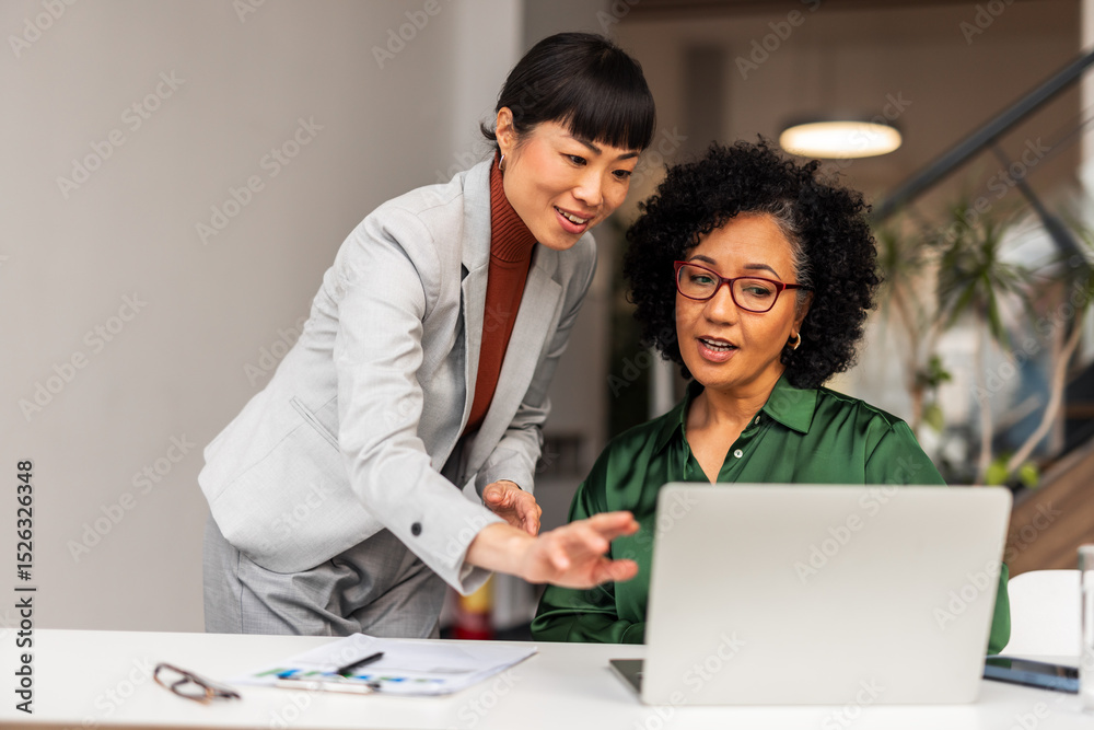 Obraz premium Professional Collaboration Between Two Women in Modern Office