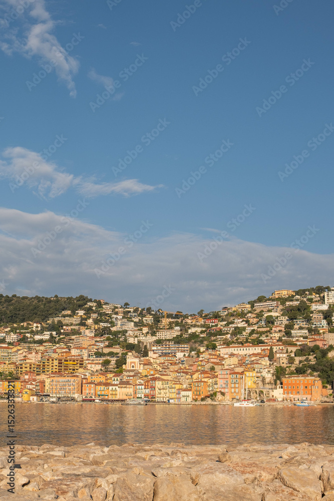 Obraz premium Resort town illuminated by the rising sun, clear blue sky and sea surface. Cote d'Azur, France