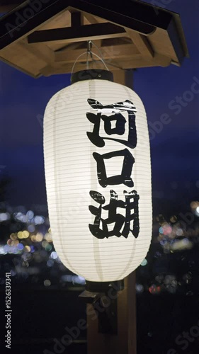 A traditional lantern illuminates the dark sky near Fujikawaguchiko, enhancing the stunning nighttime view of the city lights. Translation on lantern: ''Kawaguchi Viewpoint''. Vertical video