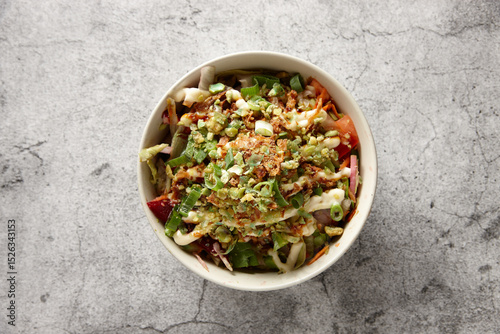 Fresh vegetable salad bowl on a concrete surface. photo