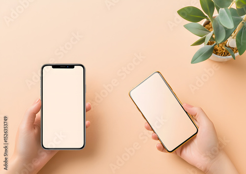 Two hands hold smartphones with blank screens against a soft peach background, accompanied by a small green potted plant.