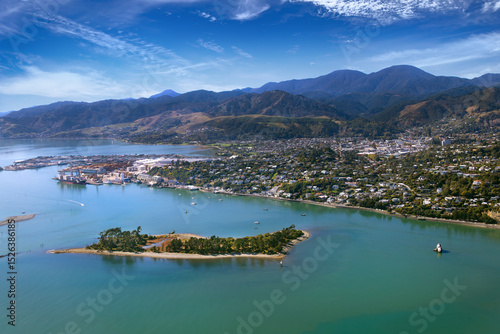Nelson, New Zealand. Aerial view of harbour, city, suburbs, port, hills, with Haulashore Island, Arrow Rock and 'The Cut', entrance to Nelson Haven from Tasman Bay. Bryant Range in distance.