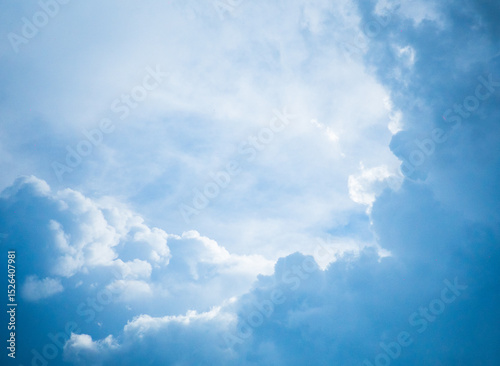 The high-resolution image shows a blue sky filled with scattered, white, cumulative clouds. Natural light emphasizes the soft texture of the clouds