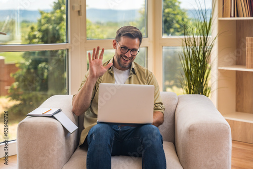 Young home-based online therapist in virtual counseling session, focused mental health professional listening to client on video call taking notes offering support and empathy in calm domestic setting