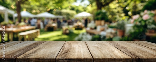 Rustic wooden table with blurred garden party background showcasing greenery and festive atmosphere in sunlight
