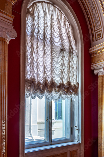 Window with arch and curtains in the palace.