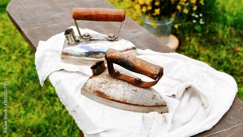 Vintage irons on wooden ironing board. Selective focus.