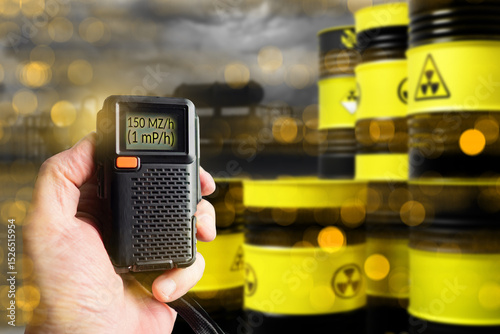 Nuclear waste. Device for measuring emissions from hazardous production. Barrels with radioactive substances. Air quality control near nuclear power plant. Hand of ecologist measuring emissions
