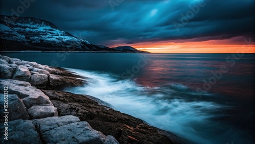 Coastal Serenity: The tranquil embrace of the sea meets the rugged beauty of the shore under a dramatic sunset sky. Evoking a sense of peace and wonder.