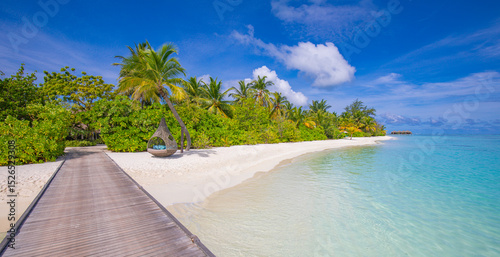 Fototapeta Naklejka Na Ścianę i Meble -  Stunning tranquil scenic Maldives paradise island long wooden jetty into tropical luxury resort. Panoramic summer vacation landscape pristine sea closeup white sand beach vibe. Sunny sky inspire shore