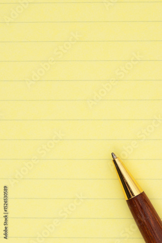 Yellow ruled legal pad paper with pen background