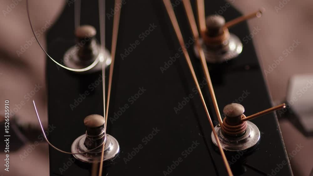 Tuning Guitar String Exploding close-up of installing new strings on an acoustic guitar, cutting off ...