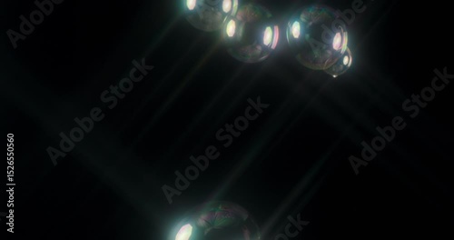 Captivating abstract and mesmerizing footage shows soap bubbles gently floating against a striking black background. This makes it perfect and ideal for motion graphics and visual effects projects