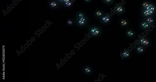 A stunning display of vibrant soap bubbles dancing against a black background, ideal for dynamic motion graphics and captivating visual effects that amaze viewers with their beauty