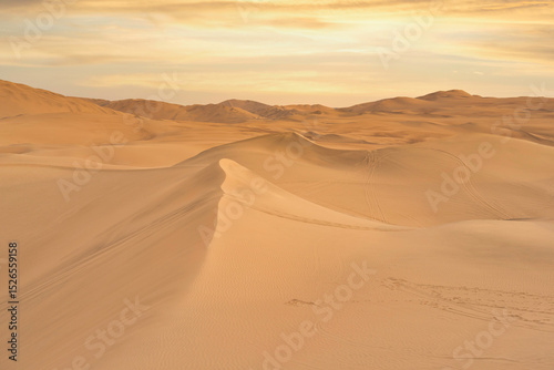 Fototapeta Naklejka Na Ścianę i Meble -  Ica desert landscape at sunset with smooth golden sand dunes near Huacachina, Peru.