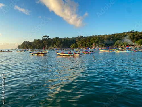 Sunrise at Pangandaran Beach, Indonesia, captured on June 9, 2025. A serene coastal scene featuring golden sunlight reflecting on gentle waves, with soft clouds and a peaceful morning atmosphere. photo