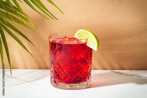 New Yorker red cocktail with whiskey, grenadine, bitter, lime and ice in glass.