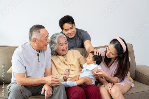 A multigenerational family gathers together, sharing warmth and love as they celebrate a special family moment with newborn. Their care strengthen bond between generations, embracing positive emotions