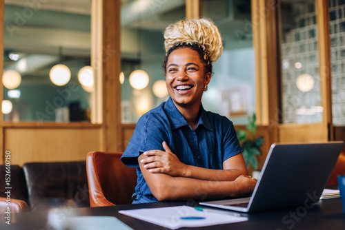 Young professional sitting at a desk with a laptop in an office
