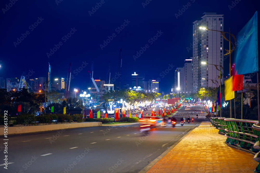 Naklejka premium Vibrant night cityscape of Da nang Vietnam with illuminated streets and modern skyscrapers