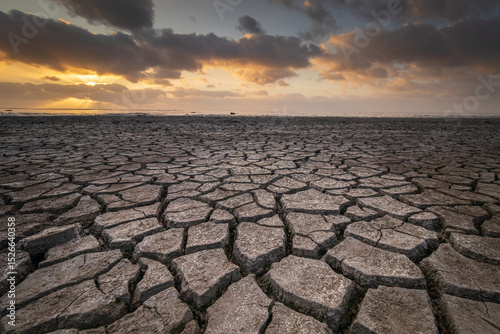 Drought on the Wadden Sea Flats Under a Threatening Sky at Sunset. The cracks create striking textures in the parched mud. Stunning piece of nature, rightfully listed as a UNESCO World Heritage site.