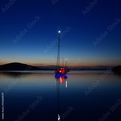 Serene Night Sailing Scene with Reflection in Calm Waters 