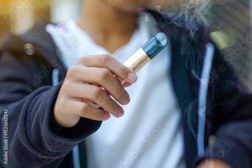 Close-up of hand holding an electronic cigarette. Soft and selective focus.