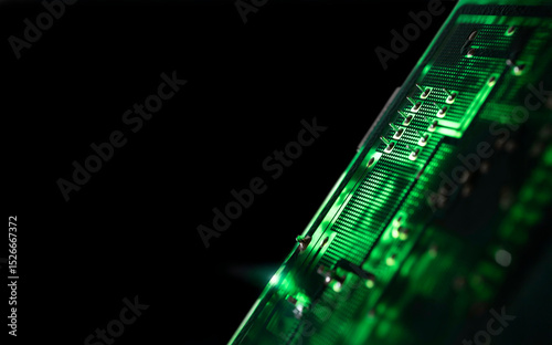 Close-up of an illuminated green electronic circuit board with many electrical components, isolated on black background, selective focus. Copy space