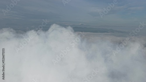 A stunning aerial view capture the serene beauty of clouds from above. Soft, billowing formations stretch across the sky, bathed in golden sunlight and casting gentle shadows over the landscape below.