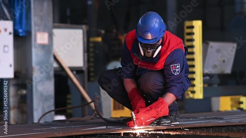 Metalworker cuts steel sheets with precision at a fabrication workshop in the afternoon sunlight