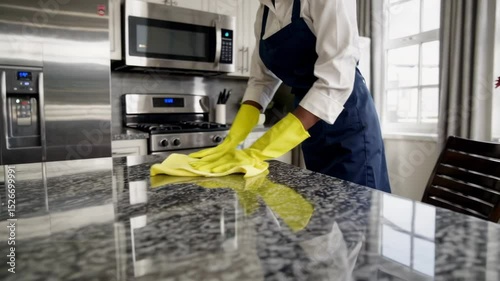 Professional housekeeper cleaning modern kitchen