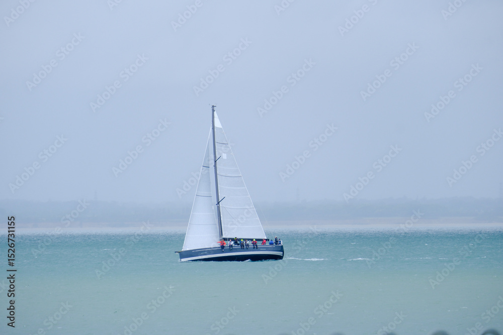 Fototapeta premium Sailing boats and yachts racing in the Isle of Wight, Round the Island Race 2025, in stormy and rainy conditions